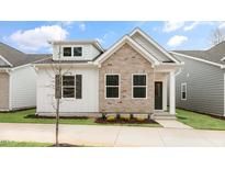 Charming home features a brick facade, white siding, and well-maintained landscaping at 802 Dorset Stream Dr, Fuquay Varina, NC 27526