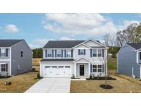 Charming two-story home with blue shutters and a two-car garage, set against a bright sky at 331 Tormore Dr, Sanford, NC 27330