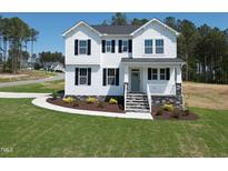 Charming two-story home featuring white siding, black shutters and a well-manicured lawn on a sunny day at 439 Duncan Creek Rd # 140, Lillington, NC 27546