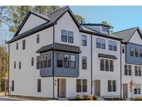 Charming three-story townhome featuring Hardie siding, black window accents, and an inviting entryway at 6408 Tanner Oak Ln, Raleigh, NC 27613