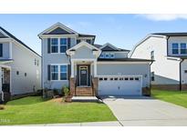 Charming two-story home with a gray exterior, complemented by well-manicured lawn and a two-car garage at 413 Edison Rail Ln, Knightdale, NC 27545