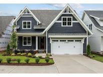 Charming craftsman-style home boasts a two-car garage and well-manicured lawn at 416 S Cross St, Youngsville, NC 27596