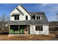 New two-story home featuring light grey siding, a dark grey roof, and a wood front door under a sunny blue sky at 103 Slocum Dr, Wendell, NC 27591