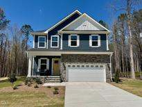 Charming two-story home with a stone facade and attached two-car garage at 196 Grand Griffon Way, Lillington, NC 27546