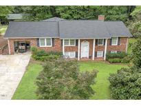 Brick ranch house with attached garage and landscaped yard at 184 Pine E St, Lillington, NC 27546