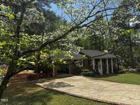 Charming brick home featuring a well-manicured lawn and driveway framed by a beautiful dogwood tree at 184 Pine E St, Lillington, NC 27546