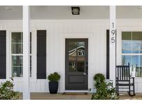 Inviting front door with glass pane and rocking chair on covered porch at 195 N Smith St, Clayton, NC 27520