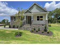 Inviting exterior showing stone accents, landscaped yard, and charming covered porch at 73 Jumper St, Wendell, NC 27591