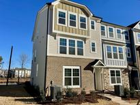 Three-story townhome with brick and siding exterior, showcasing a modern design at 3014 Freewinds Way # 45, Cary, NC 27519