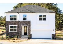 Inviting new construction home with stone and siding exterior, a garage, and manicured landscaping at 556 Barbour Farm Ln, Four Oaks, NC 27524