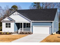 Charming blue two-story home featuring a white-trimmed porch and attached garage with a concrete driveway at 398 Fast Pitch Ln, Four Oaks, NC 27524