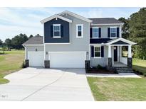 Charming two-story home featuring a three-car garage and manicured lawn, perfect for Gathering living at 576 Barbour Farm Ln, Four Oaks, NC 27524