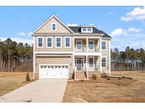 Charming two-story home featuring double porches, a two-car garage and a well-manicured front yard at 110 Bold Dr, Youngsville, NC 27596