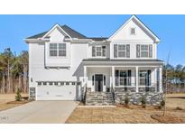 Beautiful two-story home with a white exterior and stone-accented porch at 120 Bold Dr, Youngsville, NC 27596