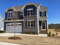 Two-story house with gray siding, stone accents, and a white garage door at 1109 Prominence Dr., Homesite 17, Durham, NC 27712