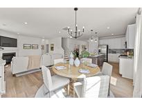 Bright dining area features modern chandelier and seating for six, perfect for Gathering meals at 516 Marthas View Way, Rolesville, NC 27587