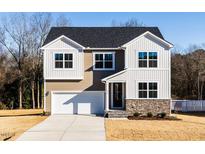 Charming two-story home featuring a two-car garage, stone accents, and a well-manicured lawn at 370 Fast Pitch Ln, Four Oaks, NC 27524