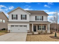 Two-story house with white siding, stone accents, and a two-car garage at 102 Campaign Dr, Mebane, NC 27302