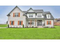 Charming two-story home featuring a brick facade, symmetrical design, and warm wooden shutters at 2590 Lassiter Rd, Four Oaks, NC 27524
