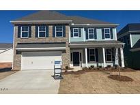 Charming two-story home with a brick and siding facade, complemented by a well-manicured front lawn at 124 August Pond Way # 138, Raleigh, NC 27603