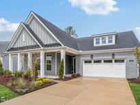 Charming home with a gray brick exterior, white trim, well-manicured landscaping, and a spacious driveway at 208 Regency Ridge Dr, Holly Springs, NC 27540