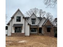 Two-story home with white siding, brick accents, and a metal roof at 4800 Lakemont Dr, Raleigh, NC 27609