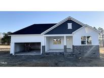 Two-story house featuring a white and blue exterior, stone accents, and a two-car garage at 818 Barbour Farm Ln, Four Oaks, NC 27524