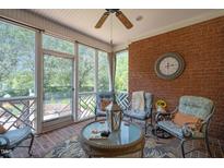 Relaxing screened porch with brick flooring and comfortable seating at 7220 Dime Dr, Raleigh, NC 27606