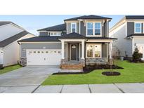 Charming two-story home features a two-car garage and a welcoming front porch with stone accents at 808 Challenger Ln, Knightdale, NC 27545