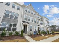 Modern townhome exterior boasts gray and white siding, stone accents, and landscaping at 448 Billingshurst Way, Knightdale, NC 27545