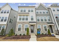 Beautifully designed three-story townhouse with stone accents and multiple windows at 506 Billingshurst Way, Knightdale, NC 27545