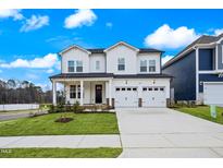 Beautiful two-story white home featuring a manicured lawn and a spacious three-car garage at 1005 Bostonian Dr, Knightdale, NC 27545