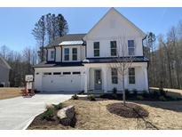 Charming two-story home featuring white siding, black accents, well-manicured landscaping, and a spacious two-car garage at 367 W Amber Oak Dr # 53, Selma, NC 27576