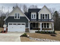 Beautiful two-story home featuring a covered front porch, an attached two-car garage, and manicured landscaping at 399 W Amber Oak Dr # 52, Selma, NC 27576