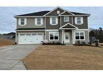 Two-story house with gray siding, white trim, and a three-car garage at 135 Newport Lndg, Garner, NC 27529