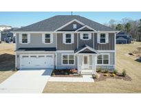 Two-story home with a two-car garage and beautifully landscaped front yard at 135 Newport Lndg, Garner, NC 27529
