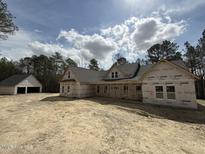 New construction home with a two car garage set among tall green trees and open sky in a rural area at 1275 Cameron Hill Rd, Cameron, NC 28326