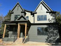 Two-story craftsman style home with dark gray siding and wood accents at 14020 Durant Rd, Raleigh, NC 27614