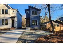 Modern two-story home featuring a blue exterior, large windows, and professionally landscaped front yard at 2708 A Ashley St, Durham, NC 27704