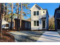 Charming two-story white home with a gravel driveway and manicured landscaping at 2708 B Ashley St, Durham, NC 27704