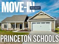 Charming single-story home featuring a two-car garage and a welcoming front porch at 21 Oakbridge Way, Pikeville, NC 27863