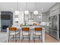 Modern kitchen features a large island with bar seating, stainless steel appliances, and stylish pendant lighting at 227 Woodsborough Pl, Raleigh, NC 27601