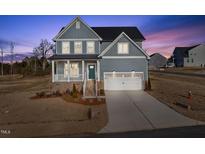 Charming two-story home with a covered porch and attached two-car garage at 22 Belmont Stakes Ln, Wendell, NC 27591
