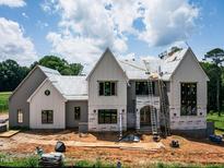 New construction home featuring multiple gables, large windows, and a modern design under a cloudy blue sky at 9105 Overlook Crest Dr, Wake Forest, NC 27587