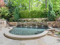Elegant kidney-shaped pool with fountain and stonework at 50211 Manly, Chapel Hill, NC 27517