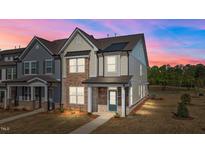 Charming townhome featuring a combination of stone and siding, complemented by a welcoming front porch at 959 Alma Railway Dr, Wake Forest, NC 27587