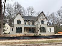 Stately new construction home featuring a stone facade, multiple gables, and classic design elements at 7208 Tanbark Way, Raleigh, NC 27615