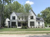 Beautiful two-story home with a manicured lawn, a stone and siding exterior, and a tree in the front yard at 7208 Tanbark Way, Raleigh, NC 27615