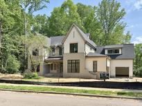 Stunning new construction home featuring stone accents, covered porch, and three-car garage at 7208 Tanbark Way, Raleigh, NC 27615
