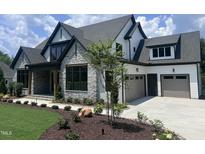 Beautiful new construction home featuring stone accents and a three-car garage at 126 Harvest Ln, Pittsboro, NC 27312